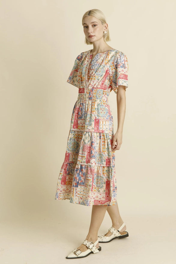 Woman wearing a colorful patterned dress on a beige background