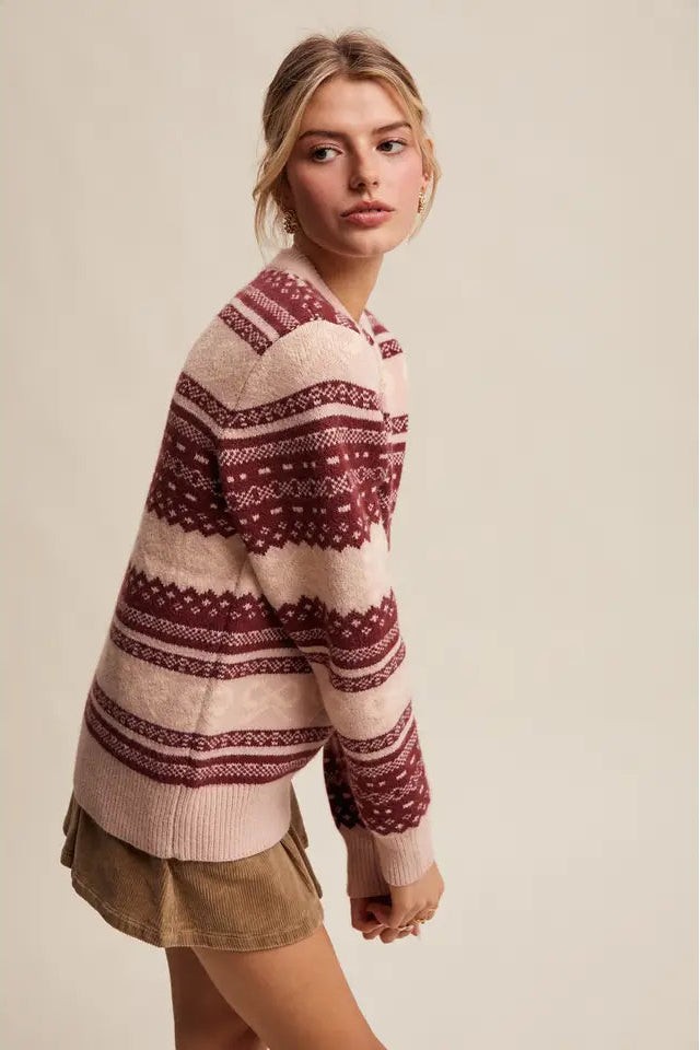 Woman wearing a patterned sweater and shorts against a plain background