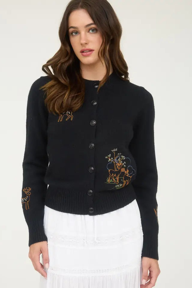 Woman wearing a black cardigan with embroidery on a white background