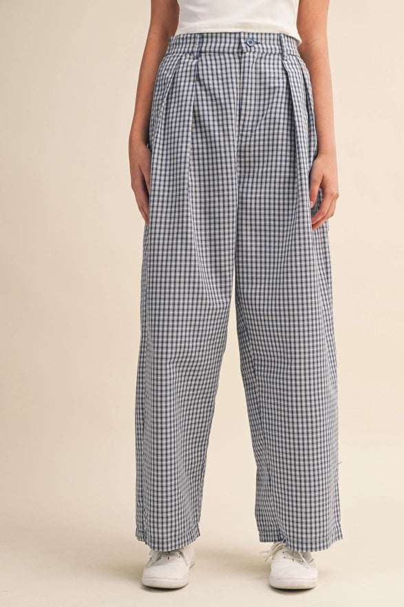 Person wearing blue and white checkered pants on a beige background