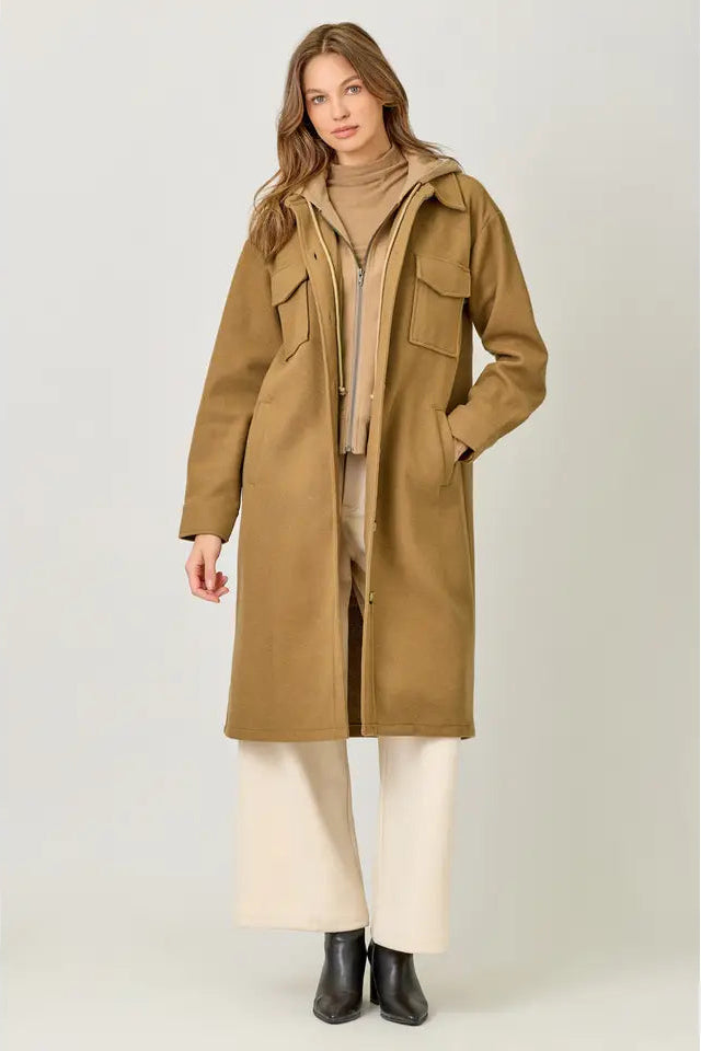 Woman wearing a long beige coat on a white background