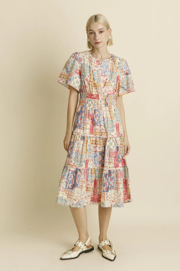 Woman wearing a colorful patterned dress on a beige background