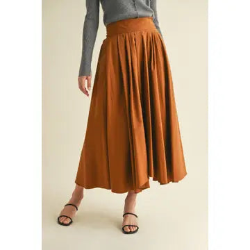 Orange skirt worn by a person on a beige background