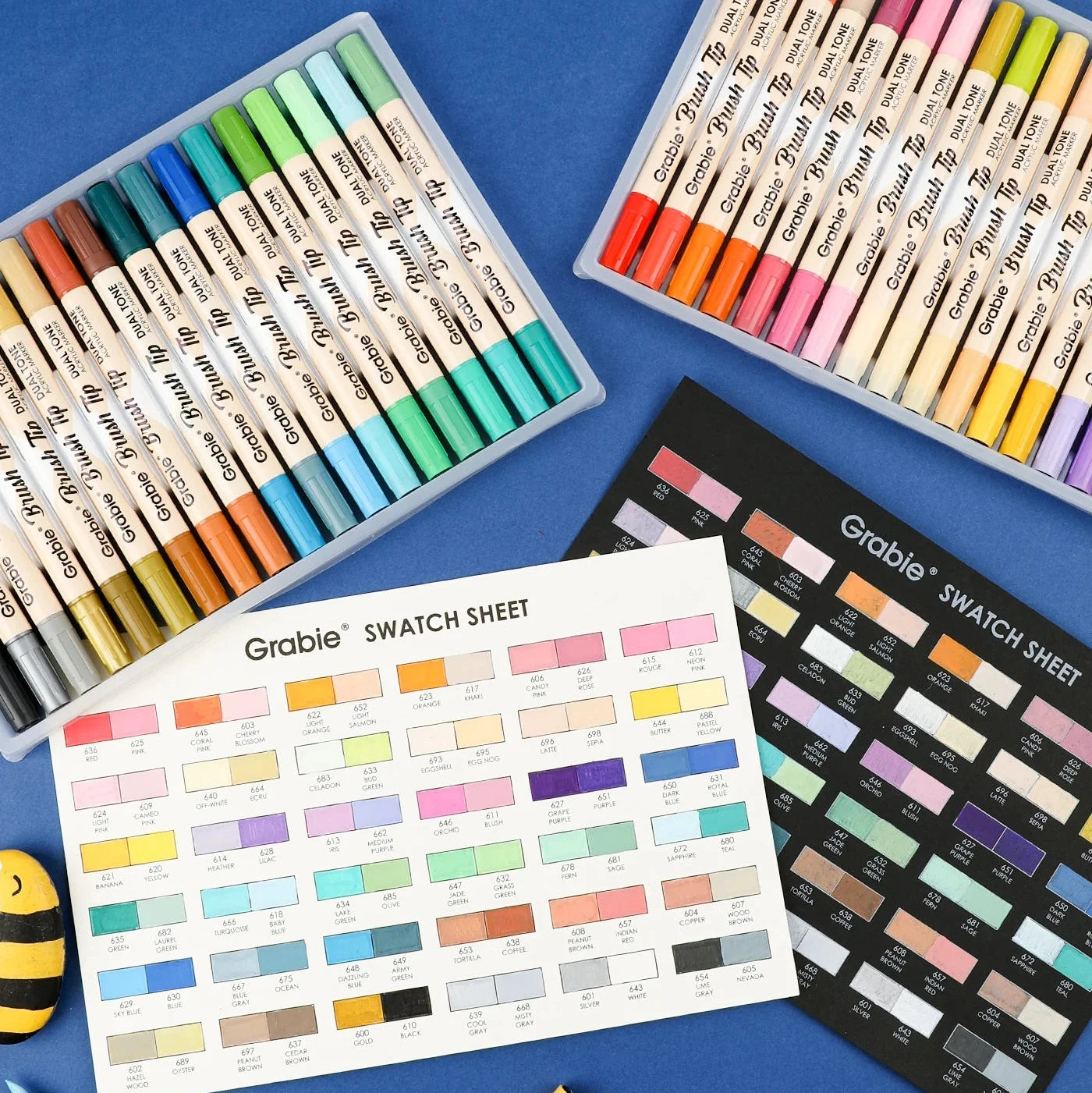 Colorful markers with swatch sheets on a blue background