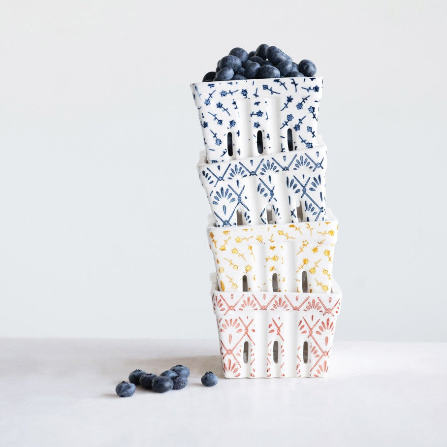Stack of patterned paper bags with blueberries on a light gray background