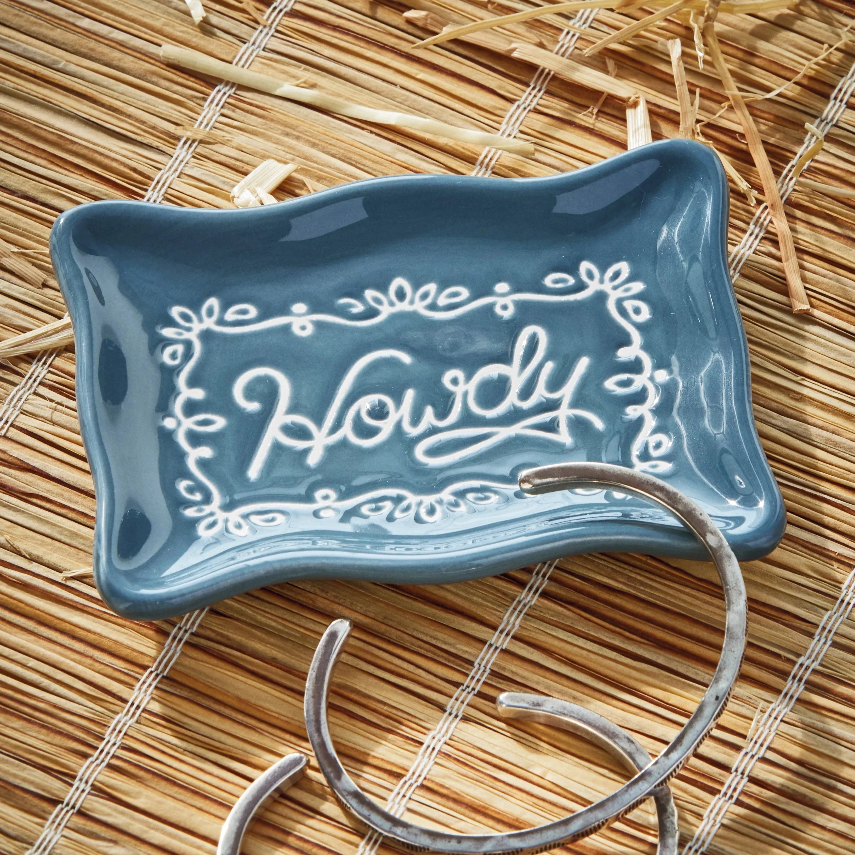 Blue ceramic dish with 'Howdy' text on a straw mat