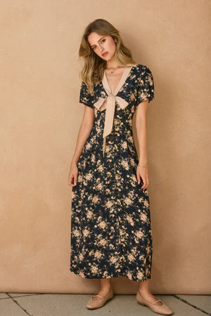 Woman wearing a floral dress against a beige wall