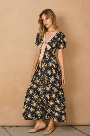 Woman wearing a floral dress against a beige wall