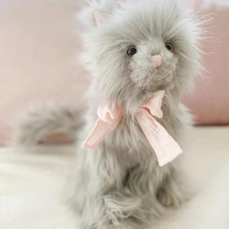 Plush toy with a pink bow on a soft background
