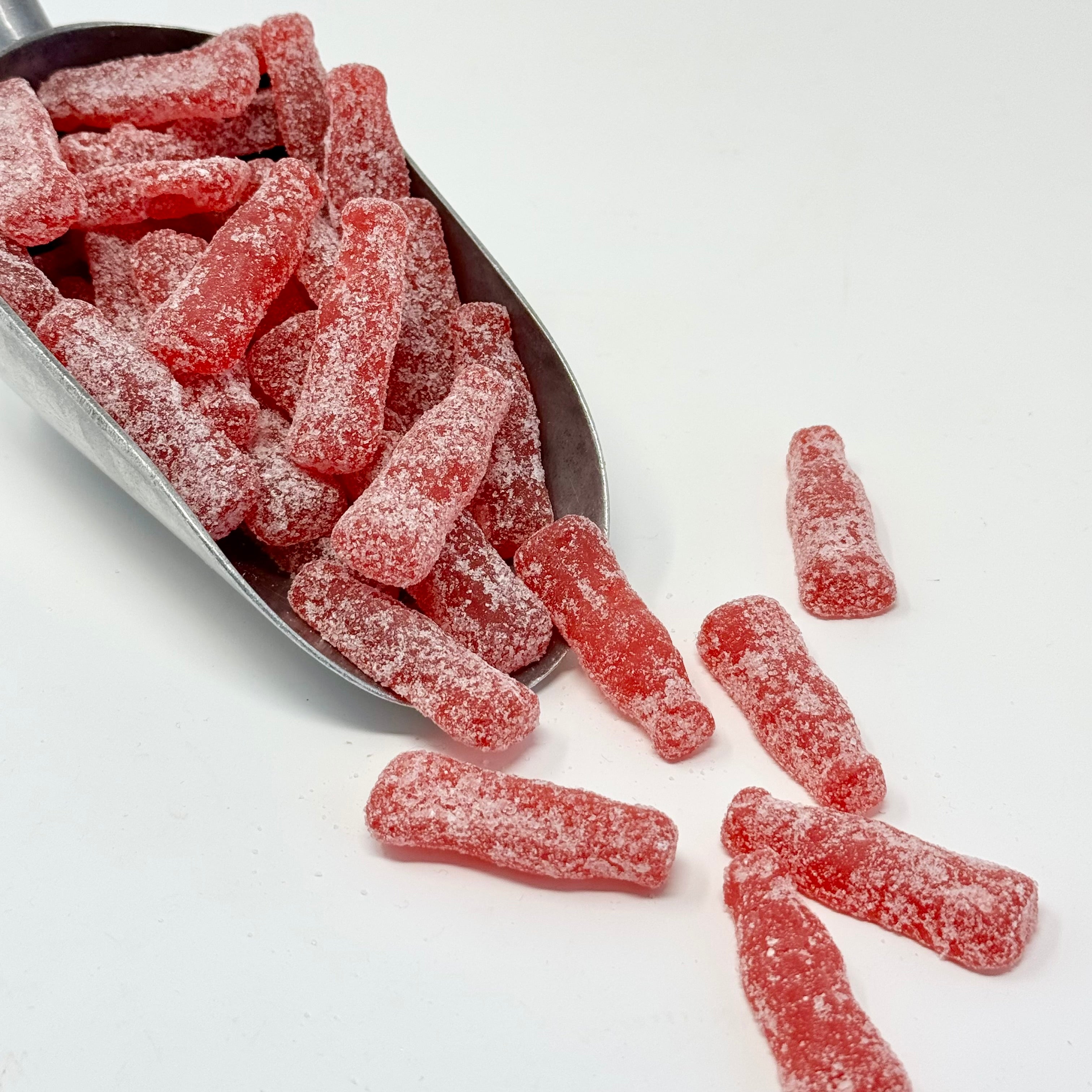Sour raspberry bottles candy  in a scoop