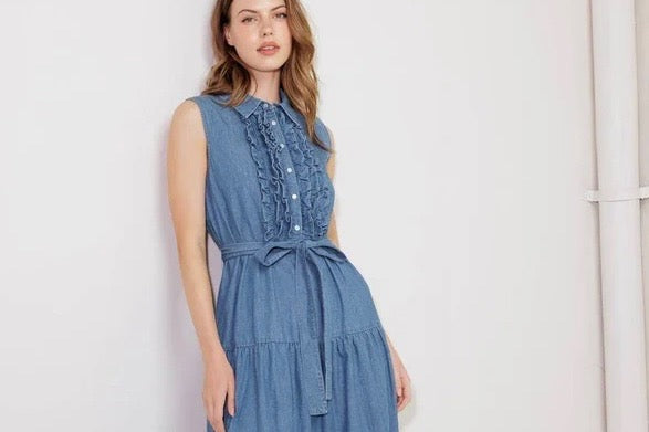 Woman wearing a blue denim dress against a white background