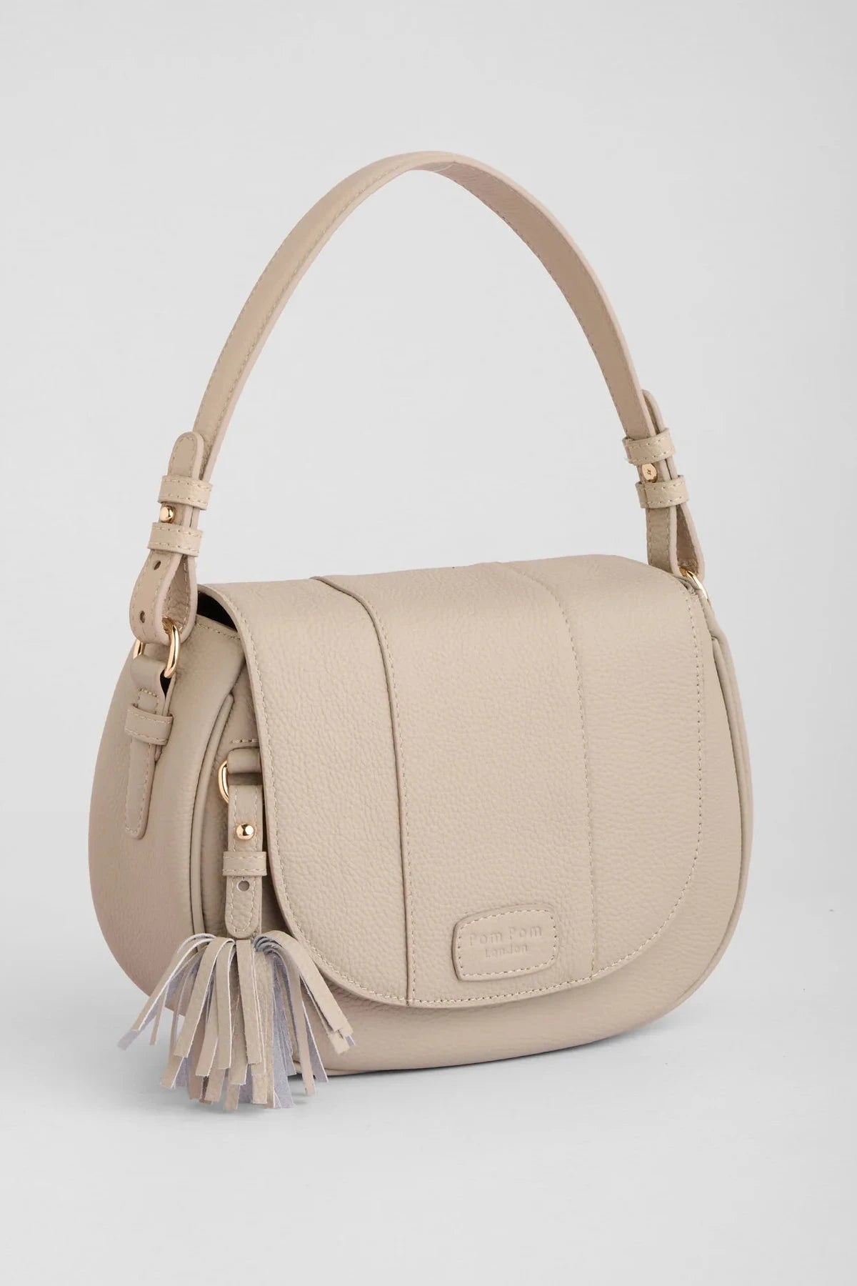 Beige handbag with tassel on a light gray background