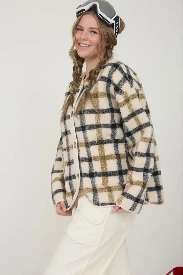 Person wearing a plaid jacket and goggles on a white background