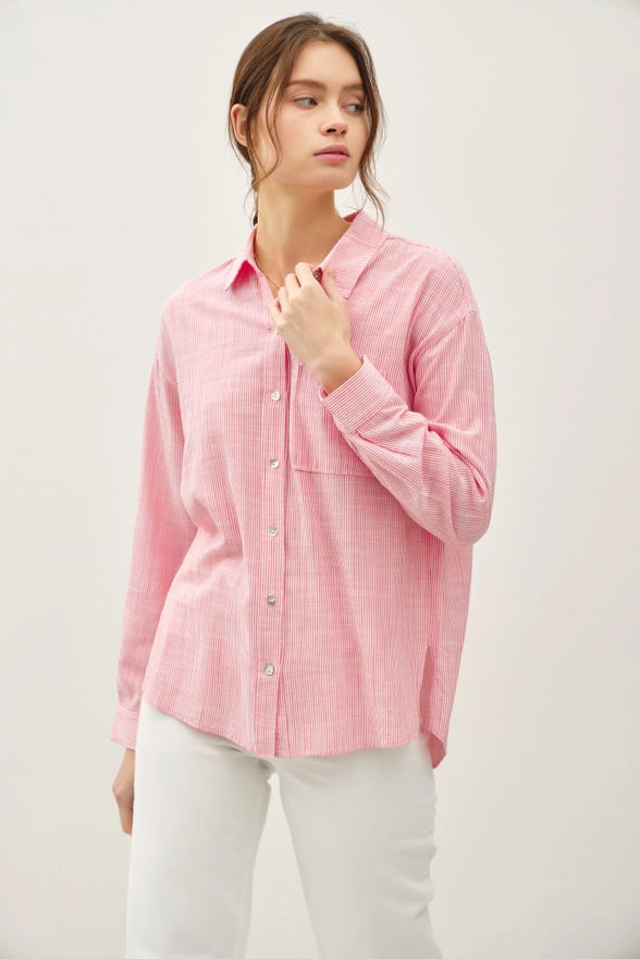Woman wearing a pink checkered shirt against a white background