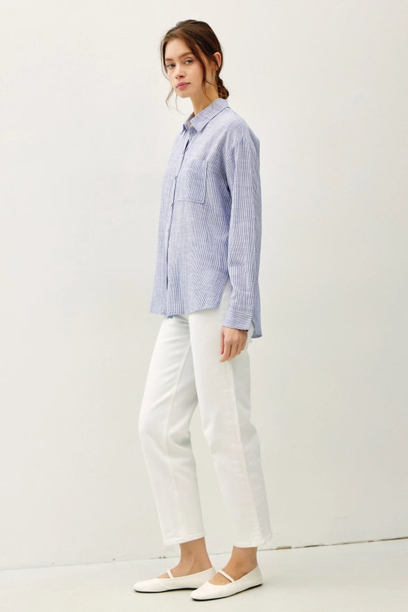 Woman wearing a blue checkered shirt and white pants on a white background