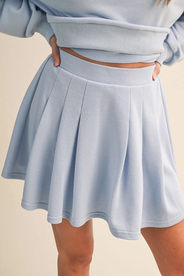 Light blue skirt worn by a person on a beige background
