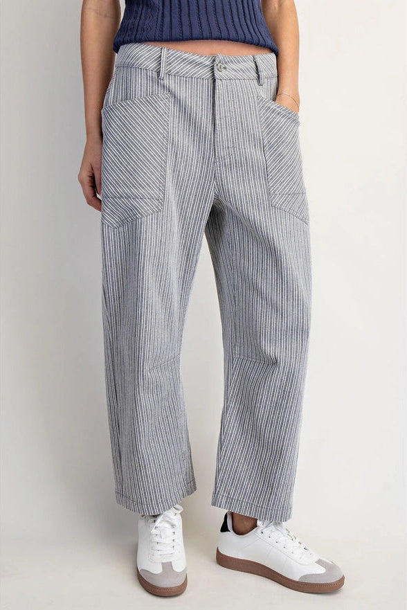 Person wearing gray striped pants with a white background