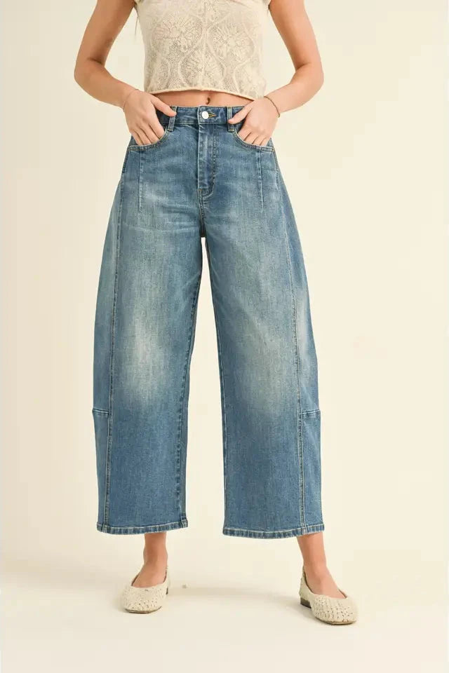 Person wearing blue jeans on a beige background