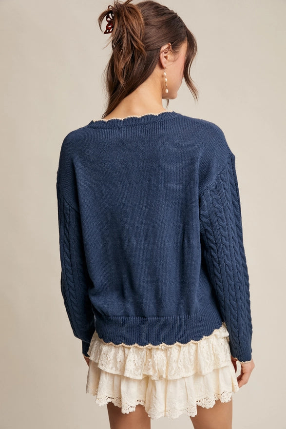 Woman wearing a blue sweater and white lace skirt on a beige background