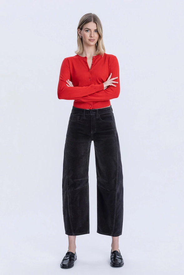 Woman wearing a red shirt and black pants on a white background
