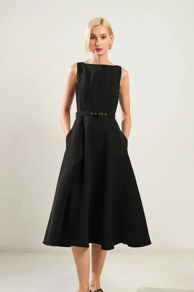 Woman wearing a black dress against a plain background