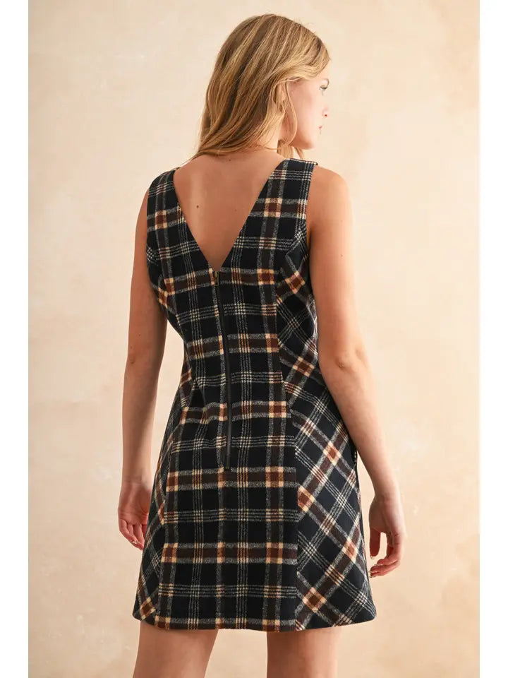 Woman wearing a plaid dress with a beige background
