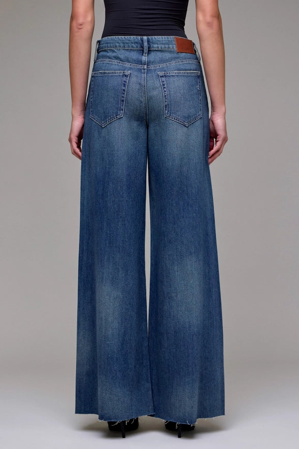 Wide-leg jeans worn by a person on a plain background