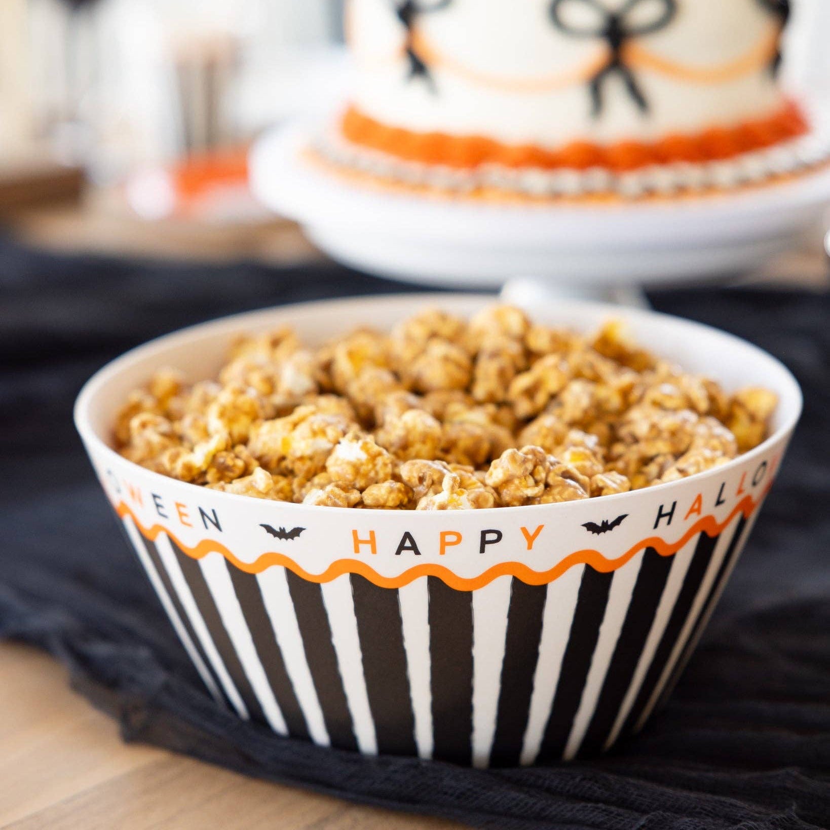 Bowl of popcorn with Halloween-themed design on a black surface