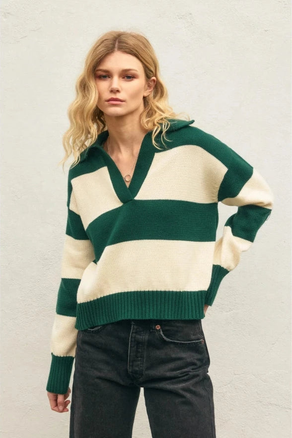 Woman wearing a green and cream striped sweater against a neutral background