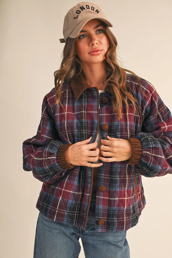 Woman wearing a plaid jacket and cap with 'London' text on a beige background