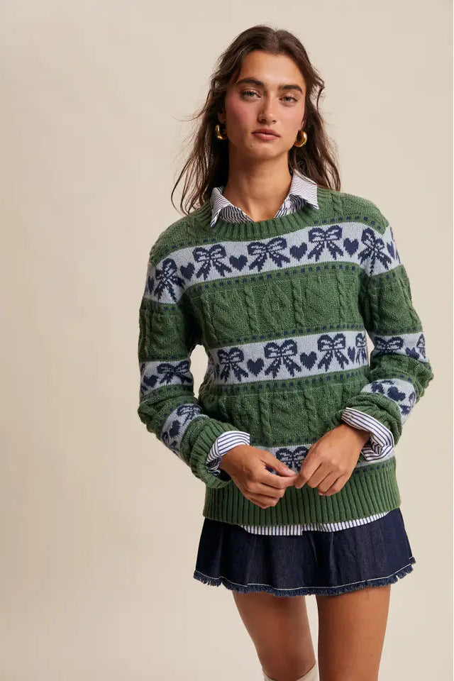 Woman wearing a green sweater with bow pattern on a beige background