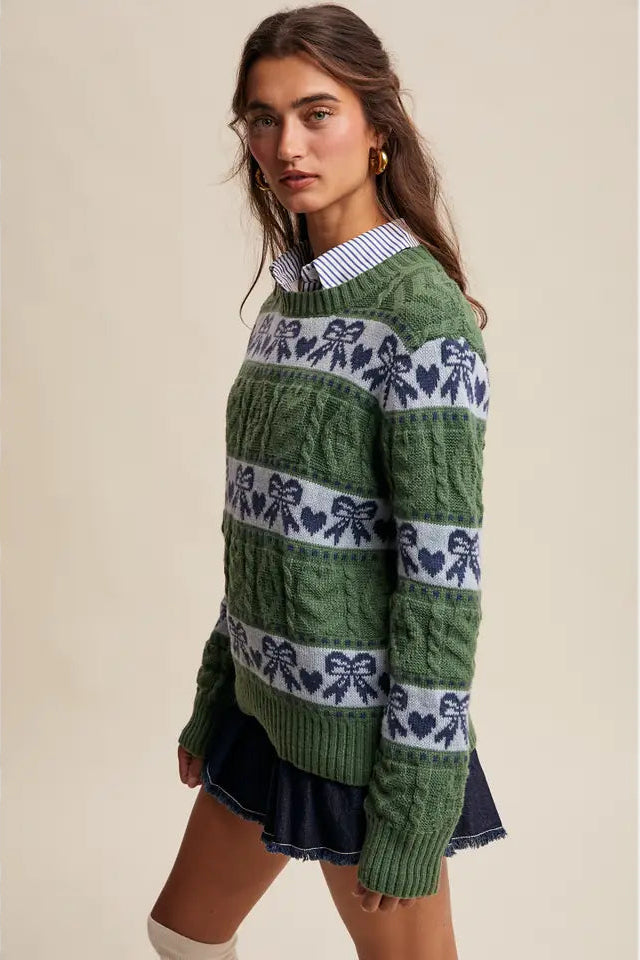 Woman wearing a green sweater with a pattern on a beige background
