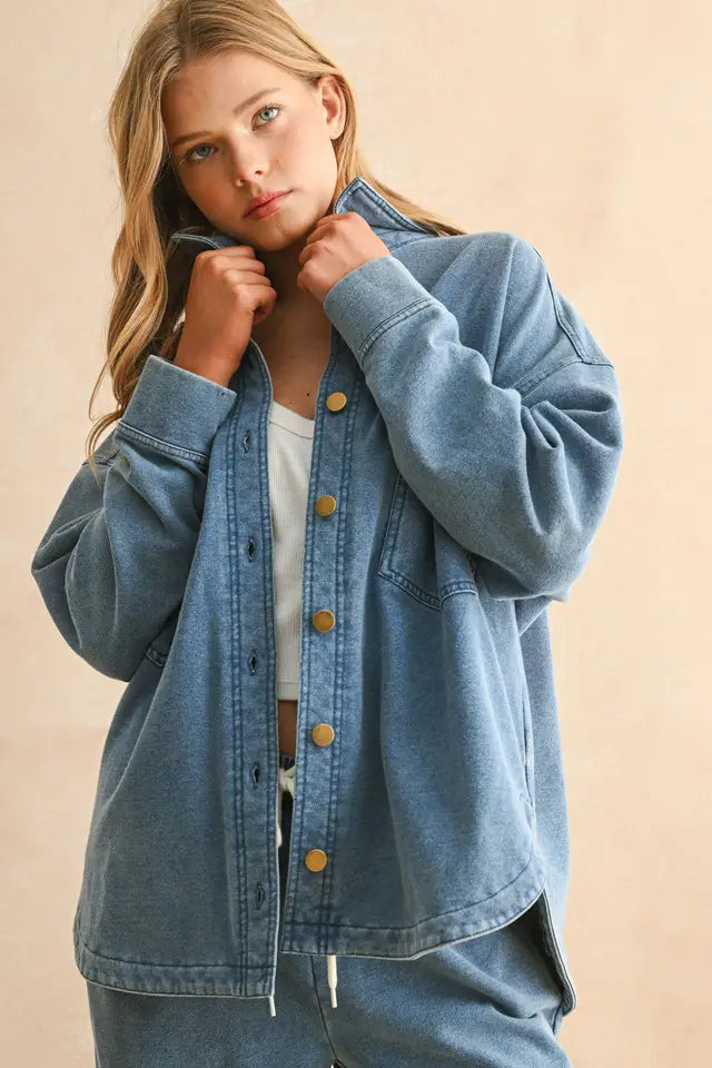 Woman wearing a blue denim jacket on a beige background