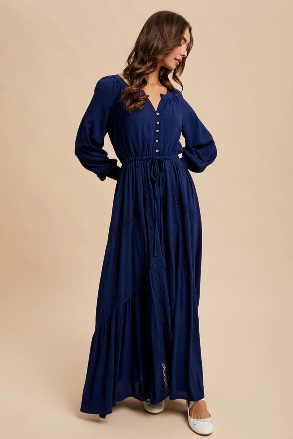 Woman wearing a navy color maxi dress with long sleeves on plain background