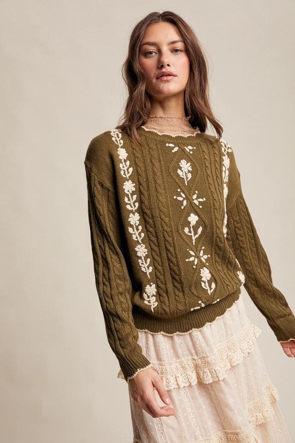 Woman wearing a brown sweater with floral patterns on a beige background