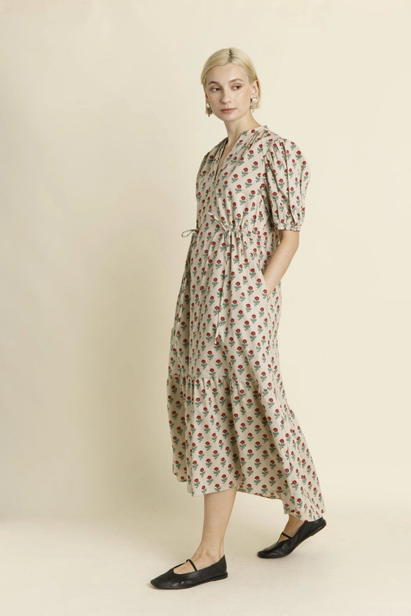 Woman wearing a floral dress against a plain background