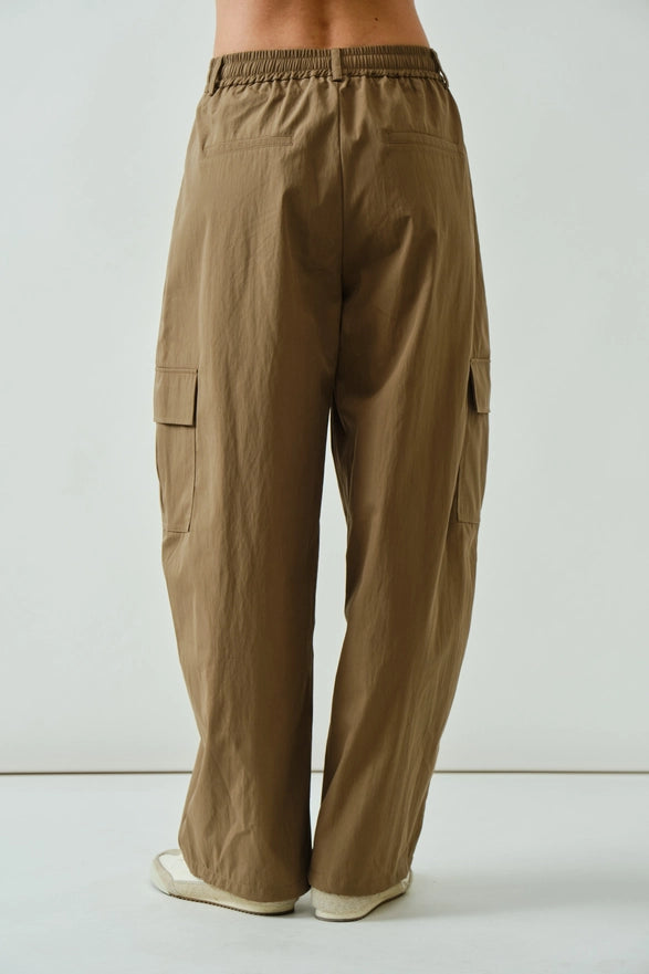 Brown cargo pants worn by a person on a light gray background