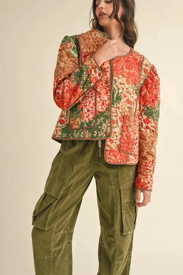Person wearing a floral jacket and green cargo pants on a beige background