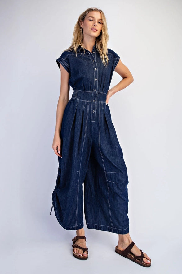 Woman wearing a denim jumpsuit on a white background
