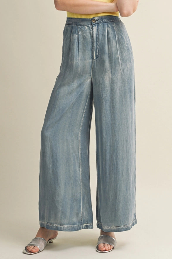 Person wearing wide-leg jeans on a plain background