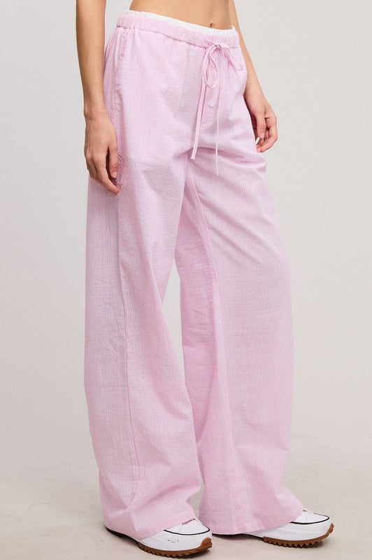 Pink pants worn by a person on a plain background