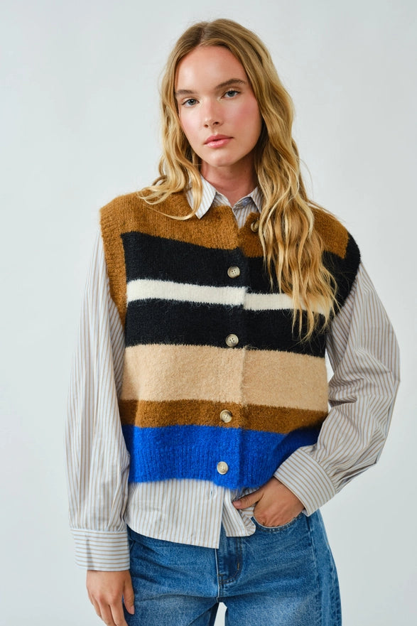 Person wearing a colorful striped sweater vest over a shirt with a white background