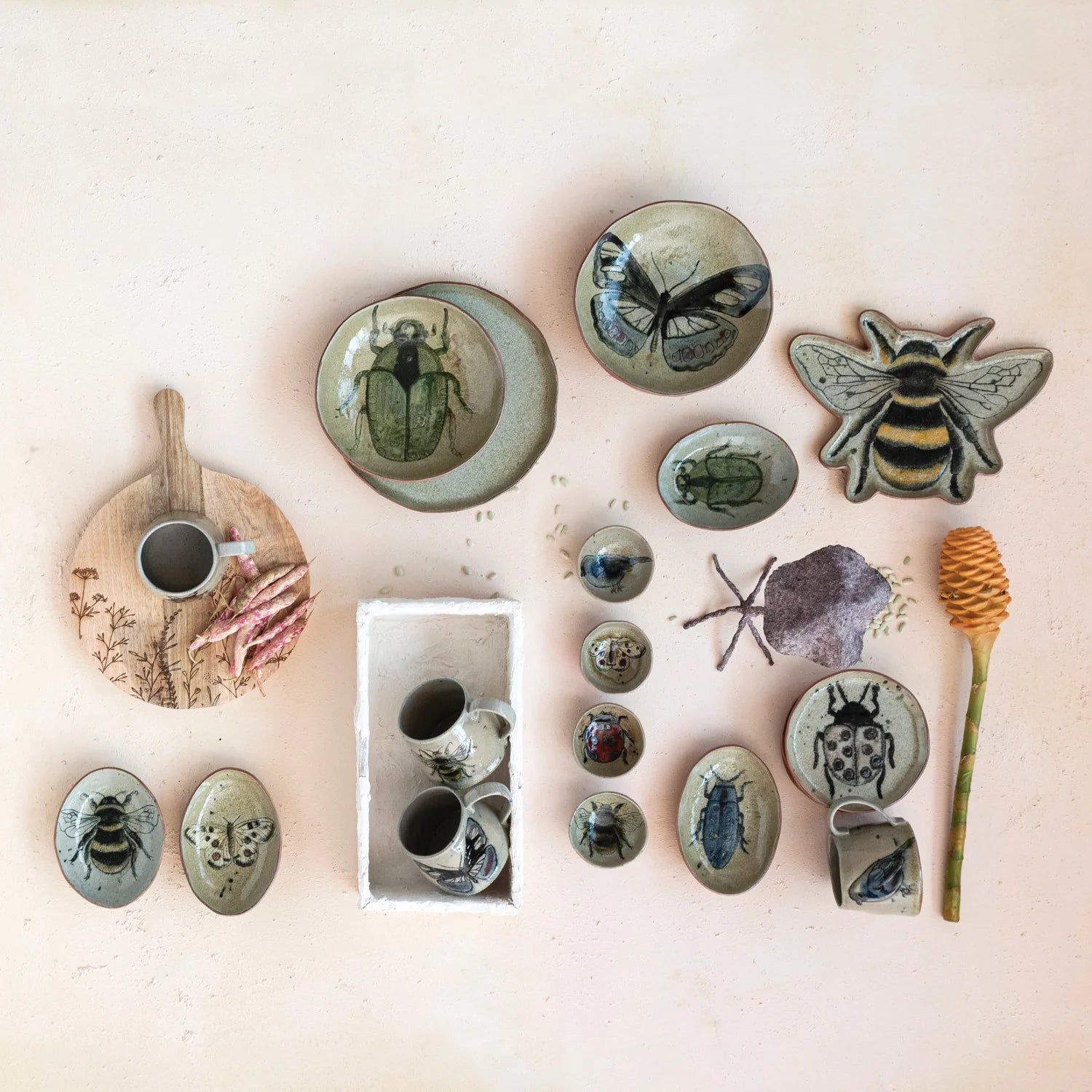 Collection of ceramic items with nature-themed designs on a light background