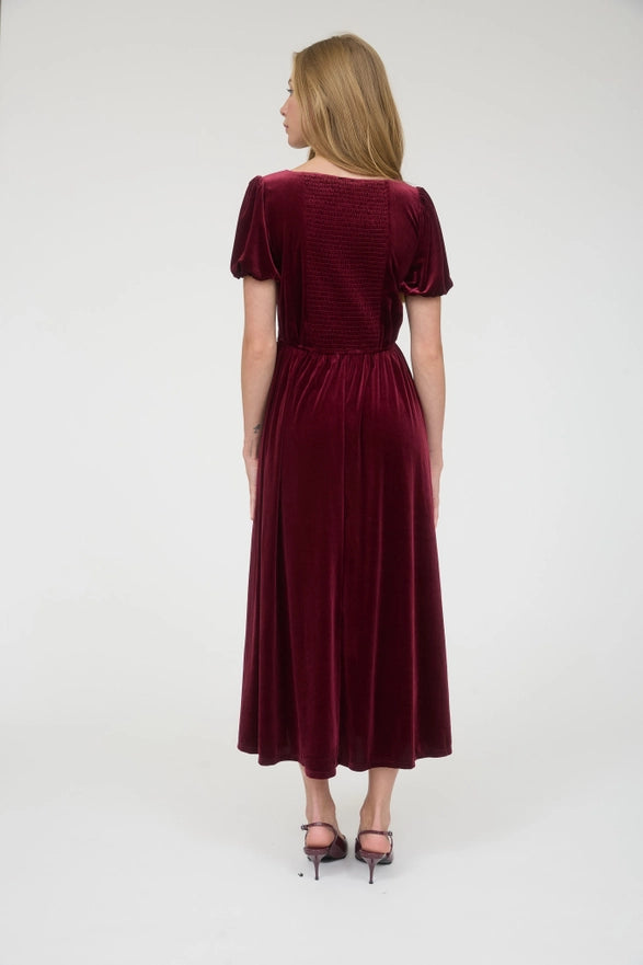 Woman wearing a burgundy dress against a white background