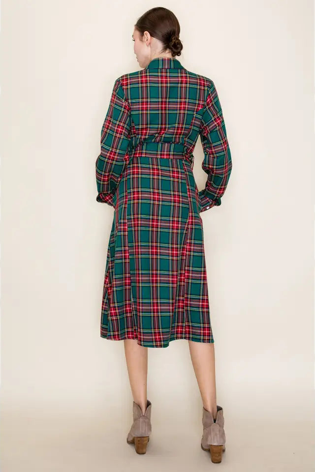 Person wearing a plaid dress with a belt on a plain background