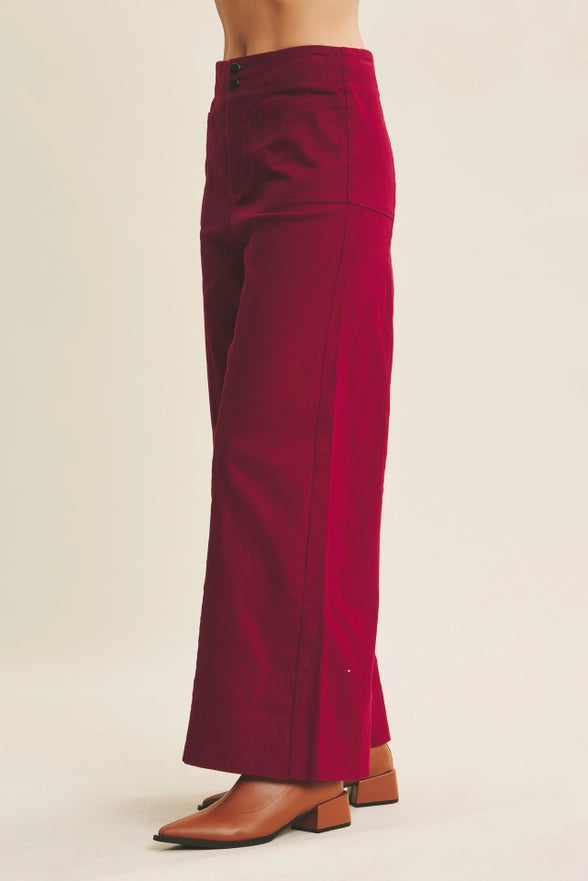 Red pants worn by a person on a beige background