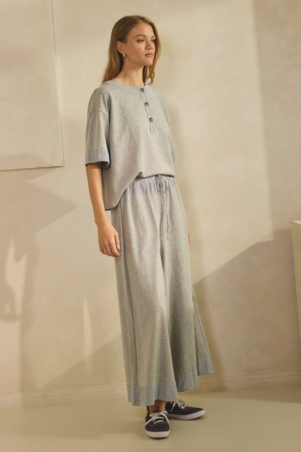 Woman wearing a light gray outfit with a plain background