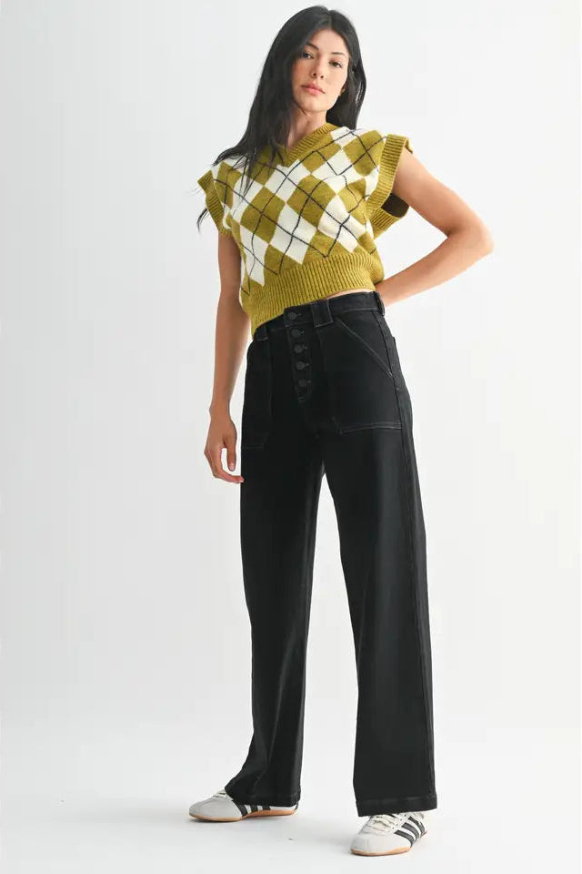 Woman wearing a green and white checkered top with black pants on a white background
