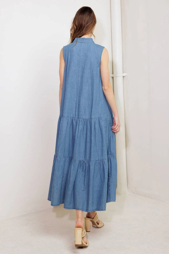 Woman wearing a blue tiered dress against a white background
