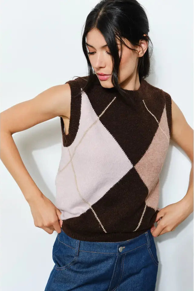 Woman wearing a sleeveless checkered sweater vest against a white background